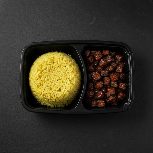 Nasi Kuning met kleine tempehstukjes in ketjapsaus in zwarte 2-vaks maaltijdbox